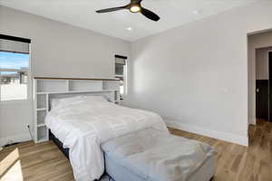 Bedroom featuring light wood-style floors, ceiling fan, and recessed lighting