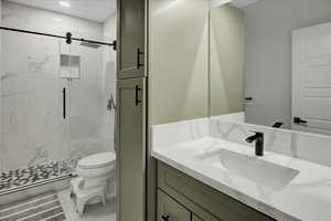 Full bath featuring a marble finish shower, vanity, and recessed lighting
