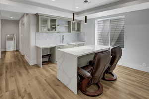 Bar with light wood finished floors, decorative light fixtures, decorative backsplash, and recessed lighting