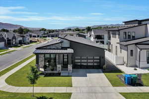 View of front of property featuring a residential view, driveway, stone siding, and a mountain view