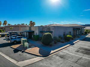 View of front of home with stucco siding and uncovered parking