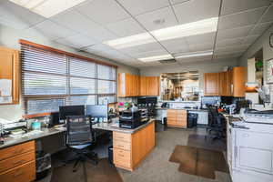 Office area with a drop ceiling and built in desk