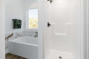 Full bath with a garden tub, a shower, and wood finished floors