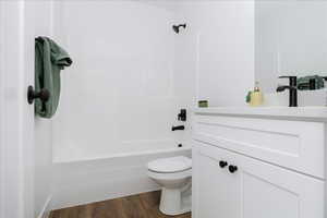 Full bath featuring vanity, shower / bath combination, and wood finished floors