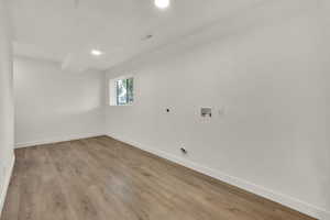 Laundry room with electric dryer hookup, washer hookup, wood finished floors, and recessed lighting