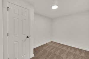 Empty room featuring carpet and baseboards
