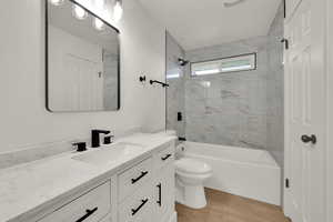 Bathroom featuring vanity, bathtub / shower combination, and wood finished floors