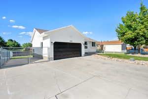 View of home's exterior with a gate, concrete driveway, and a garage