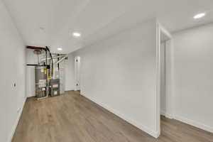 Workout room featuring recessed lighting, wood finished floors, water heater, and heating unit