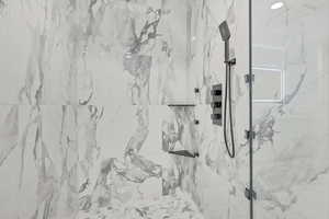Bathroom featuring a marble finish shower