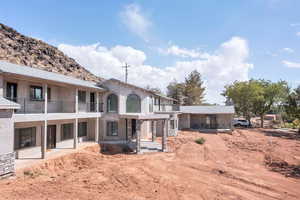 Back of property with a patio, a balcony, and stucco siding