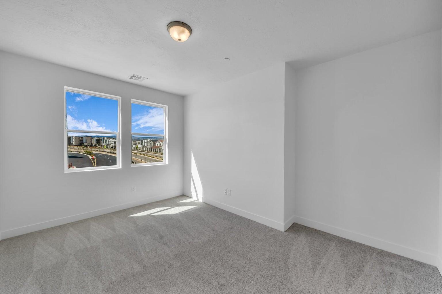 Carpeted spare room featuring baseboards