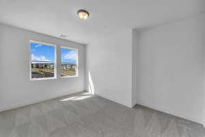 Carpeted spare room featuring baseboards