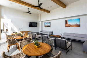 Dining area with ceiling fan, beamed ceiling, a towering ceiling, and tile patterned flooring