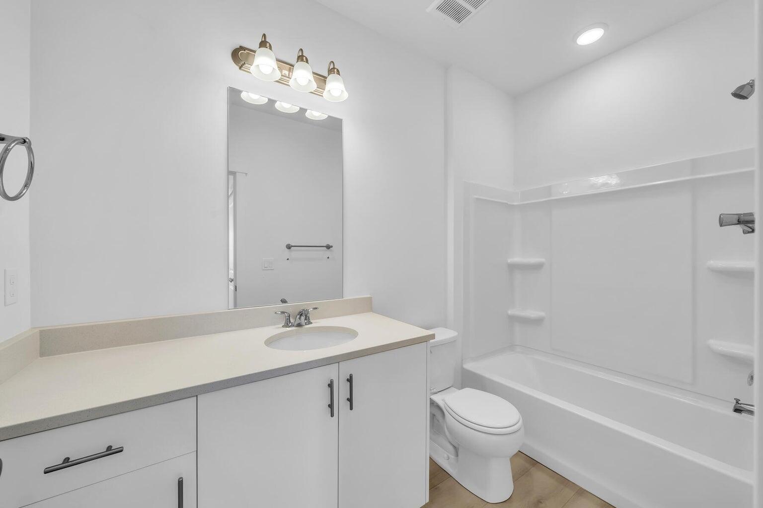 Full bathroom featuring vanity, shower / washtub combination, and wood finished floors