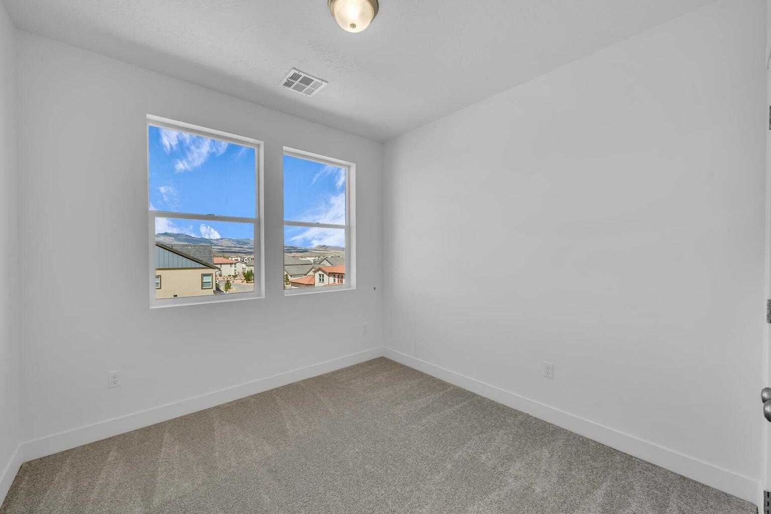 Empty room featuring carpet flooring and baseboards