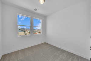 Empty room featuring carpet flooring and baseboards