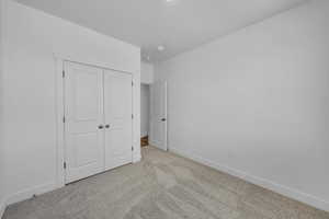 Unfurnished bedroom featuring carpet and a closet