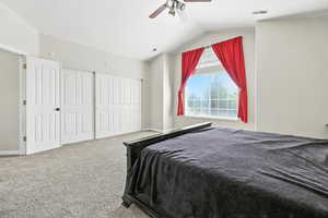 Bedroom with carpet floors, vaulted ceiling, a closet, and a ceiling fan
