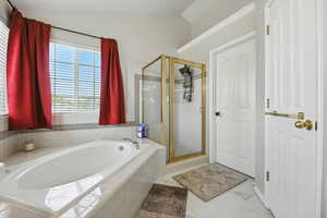 Bathroom featuring vaulted ceiling, a bath, and a shower stall