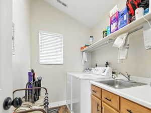 Laundry room with independent washer and dryer, light tile patterned floors, and cabinet space