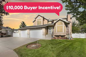 View of front of property with a gate, driveway, a chimney, and brick siding