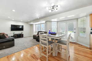 Dining area featuring a textured ceiling, light wood-style flooring, and recessed lighting