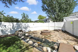 Fenced backyard with an outdoor fire pit and a patio area