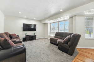 Living area with recessed lighting, a textured ceiling, and wood finished floors