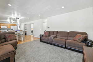 Living area featuring recessed lighting, light wood-type flooring, and a textured ceiling