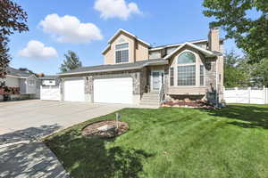 Traditional-style house with a chimney, driveway, stucco siding, and a gate