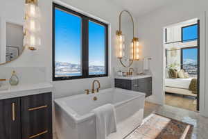 Full bathroom featuring a freestanding tub, vanity, connected bathroom, and a mountain view
