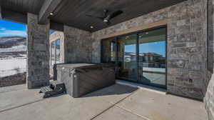View of patio featuring a ceiling fan and a hot tub