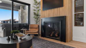 Detailed view of a glass covered fireplace, wood finished floors, and wooden walls