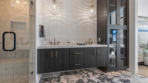 Full bathroom with double vanity, a stall shower, and marble finish flooring