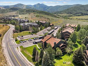 Aerial view of property and surrounding area featuring a mountain backdrop and nearby suburban area