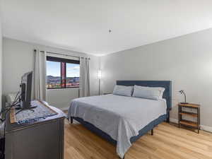 Bedroom with light wood finished floors and baseboards