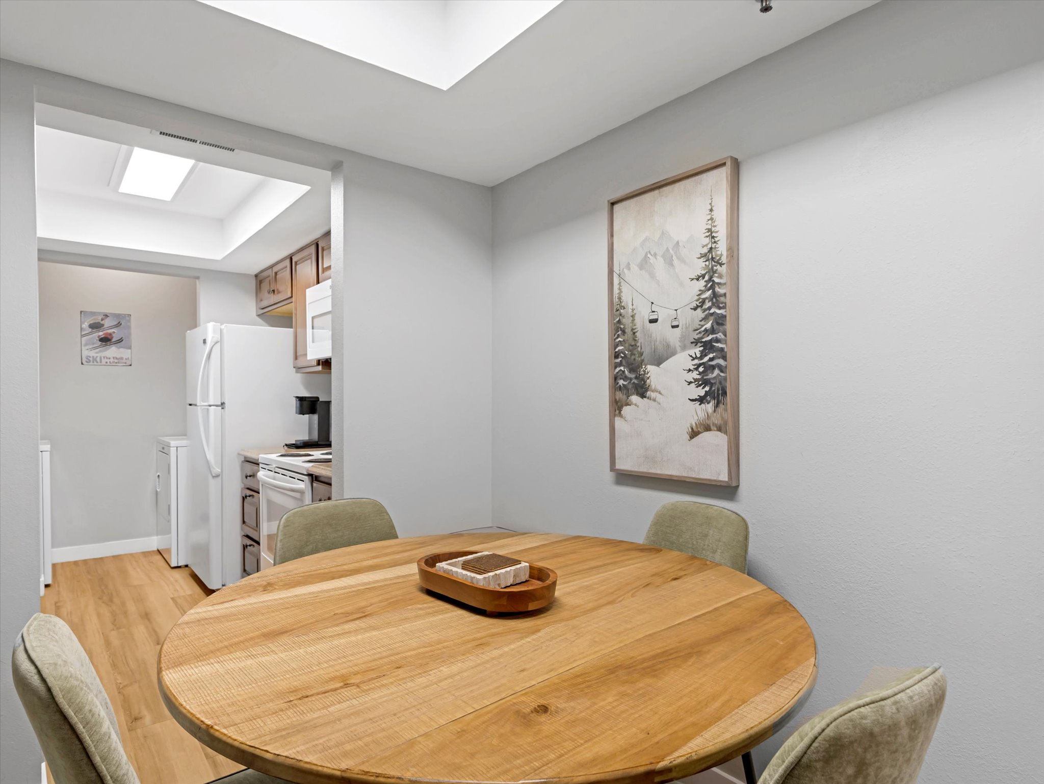 Dining space with light wood finished floors and a tray ceiling