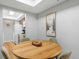 Dining space with light wood finished floors and a tray ceiling