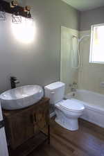 Full bathroom featuring tub / shower combination, wood finished floors, and vanity