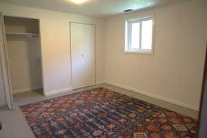 Unfurnished bedroom with a textured ceiling and two closets
