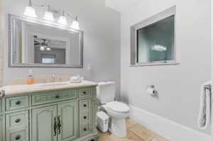 Bathroom with vanity, a ceiling fan, and tile patterned flooring