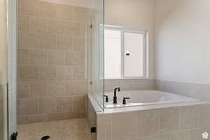 Bathroom featuring a bath and a shower stall