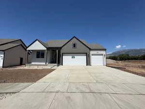 Ranch-style house featuring an attached garage, roof with shingles, driveway, and stucco siding