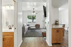 Living room with wood finished floors, a textured ceiling, and a ceiling fan