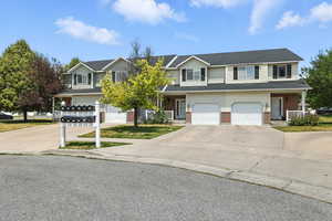 Traditional-style house featuring a porch, concrete driveway, and brick siding