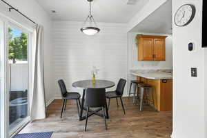 Dining space with light wood-type flooring and wooden walls