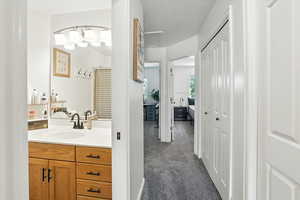 Full bathroom with vanity and a textured ceiling