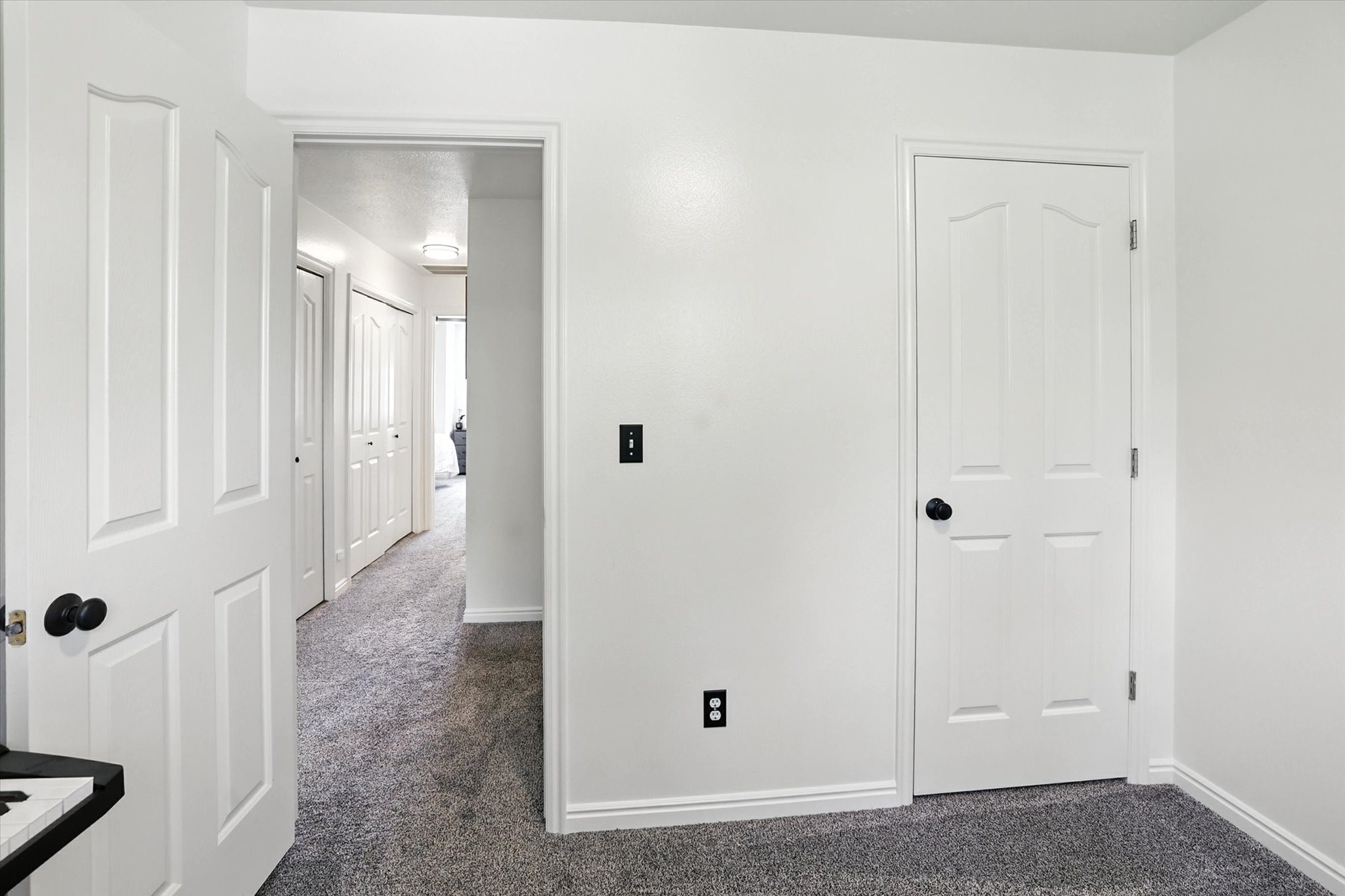 Unfurnished bedroom with dark colored carpet