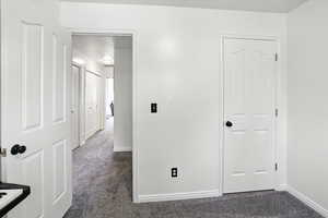 Unfurnished bedroom with dark colored carpet